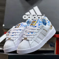 Zapatilla Adidas Unisex Superstar Blanco Azul y Dorado